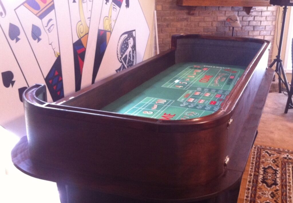 Casino craps table in front of a wall with card design