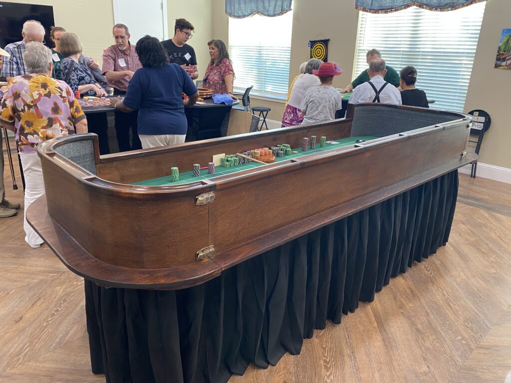 Casino craps table with people at the back playing